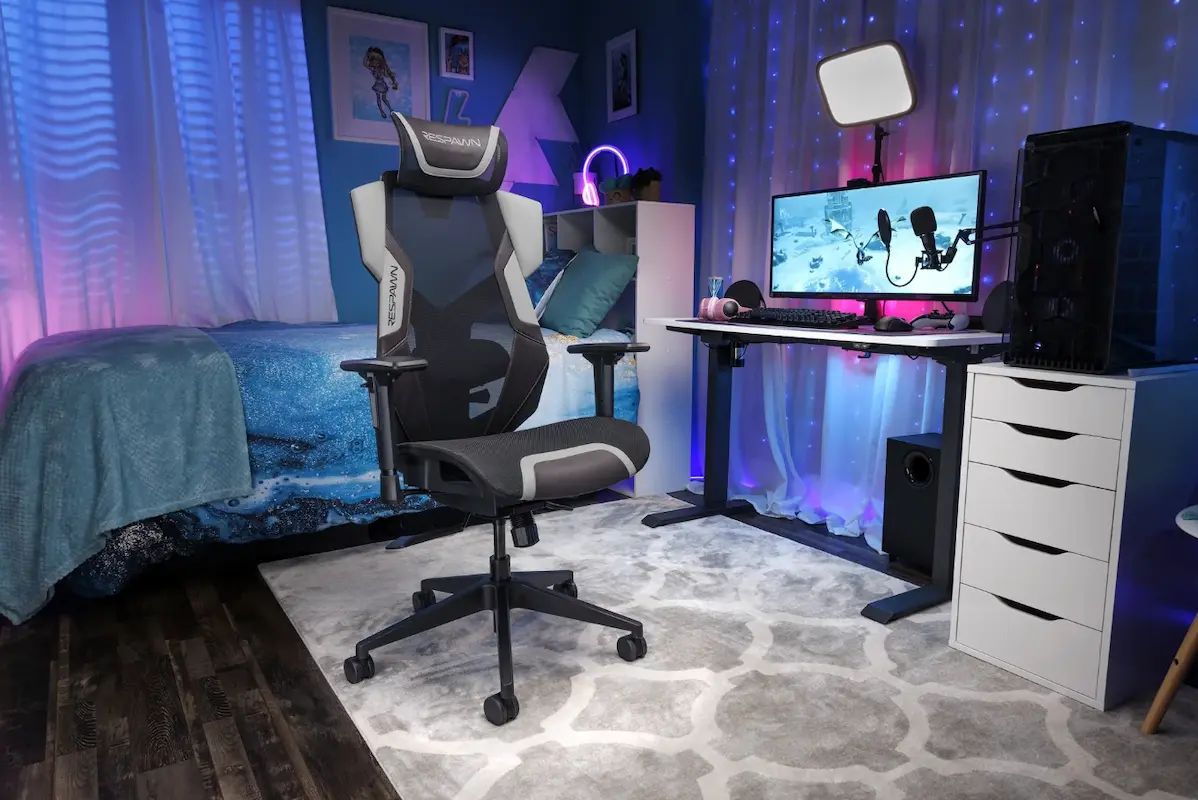 Quarto com setup gamer montado e destaque para a cadeira gamer preta com detalhes em cinza.