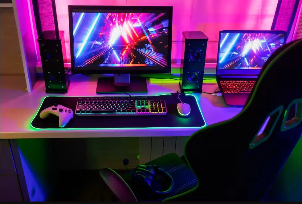Setup gamer completo composto por mesa, monitor, caixa de som, teclado, mouse gamer e iluminação RGB.