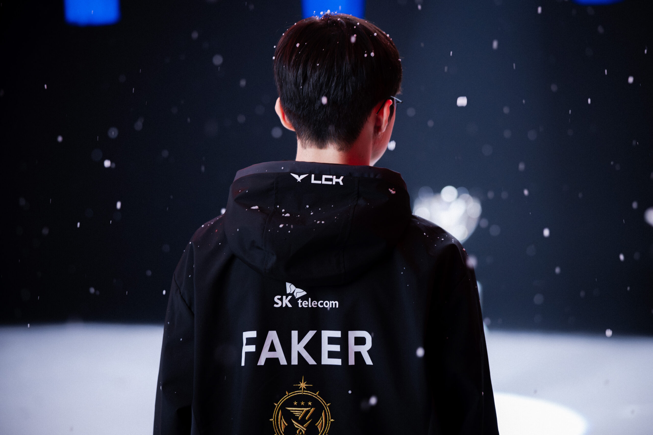 jogador_de_lol_faker_coberto_por_flocos_de_neve_e_de_costas jogaor de LoL, Faker posando para foto coberto por flocos de neve. marco histórico