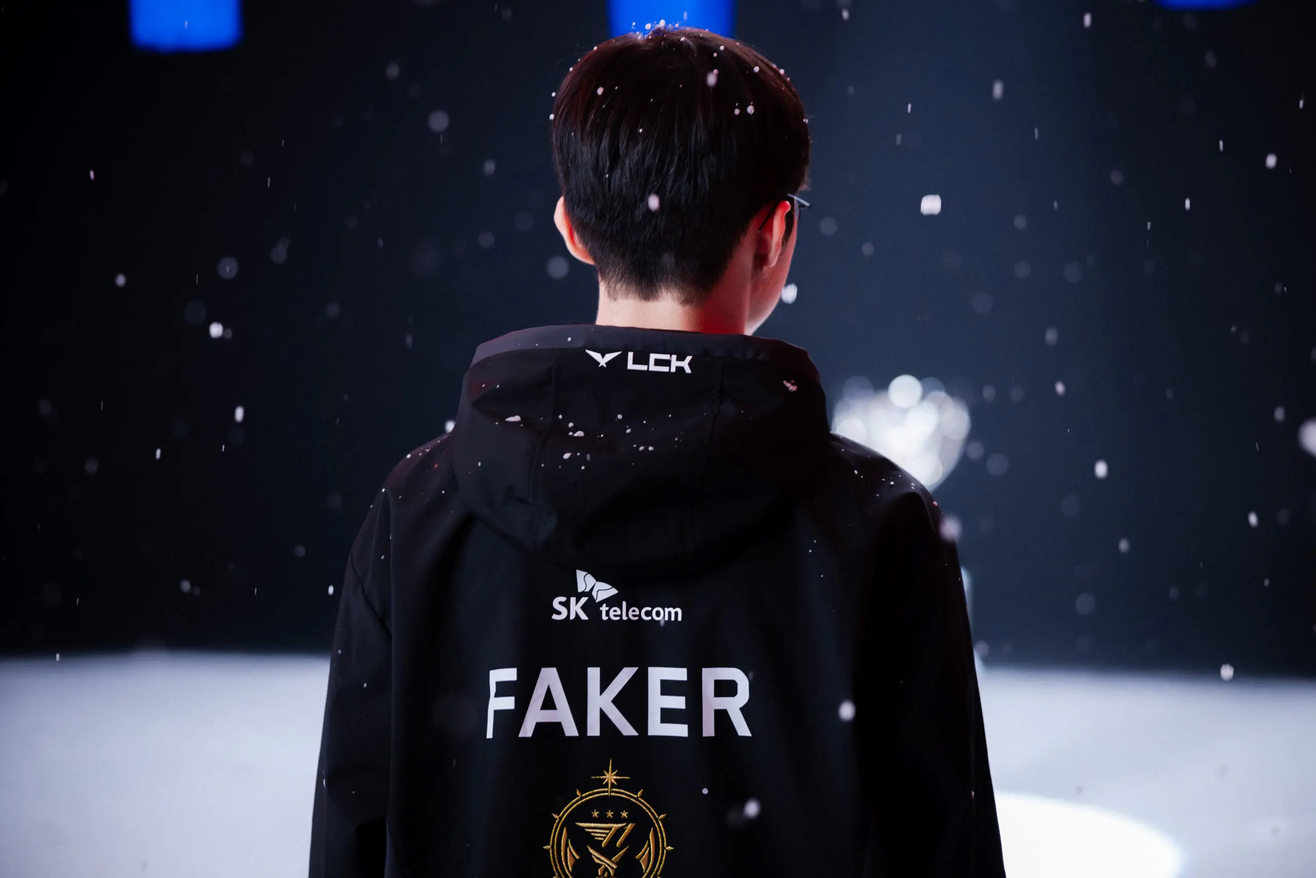 jogaor de LoL, Faker posando para foto coberto por flocos de neve. marco histórico
