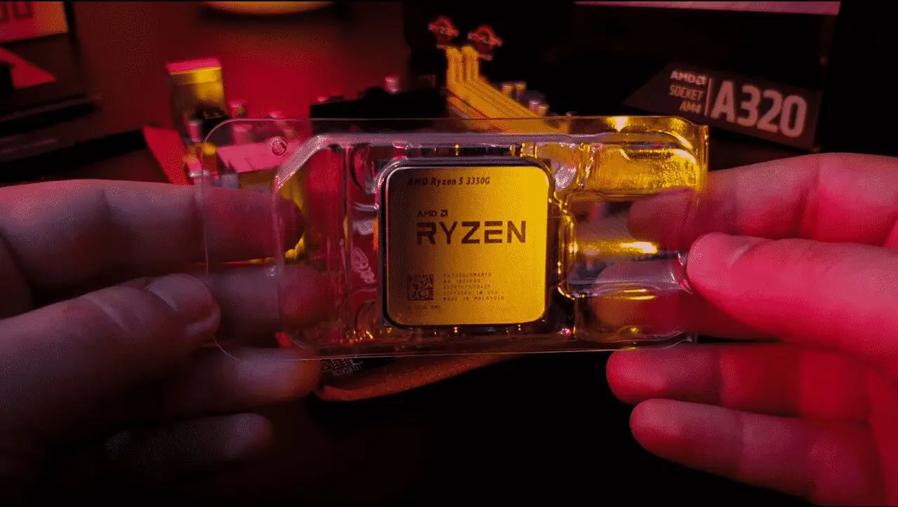 Mãos segurando o processador AMD Ryzen com luz amarelada iluminando a embalagem.