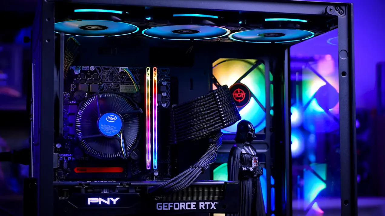 Interior do gabinete de um PC gamer com placa GeForce RTX, memórias RGB e ventoinhas iluminadas.