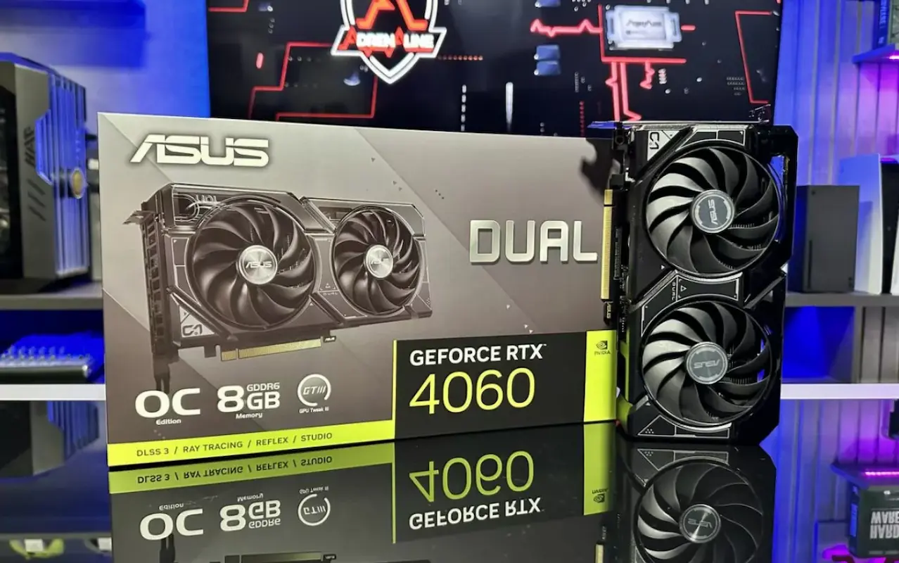 Placa de vídeo ASUS Dual GeForce RTX 4060 (8 GB) sob placa espelhada e setup gamer no fundo.