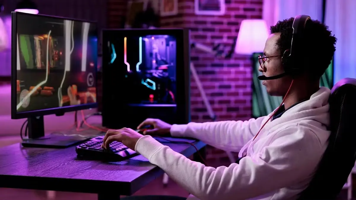 Homem sentado, desfrutando de uma partida sem grandes variações de temperatura e consumo de energia no seu PC.